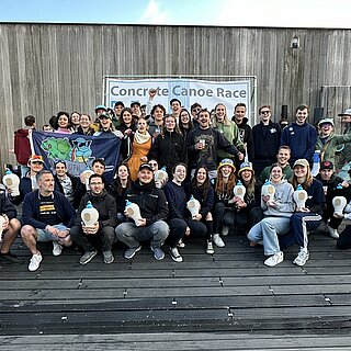 Gruppenfoto auf einer Holzterrasse.