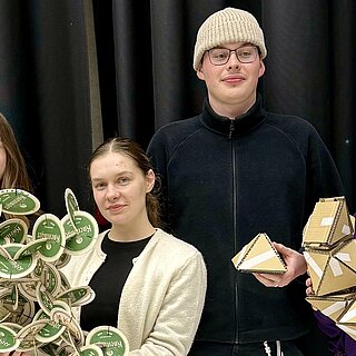 Vier Studierende halten selbstgebauten Modelle 