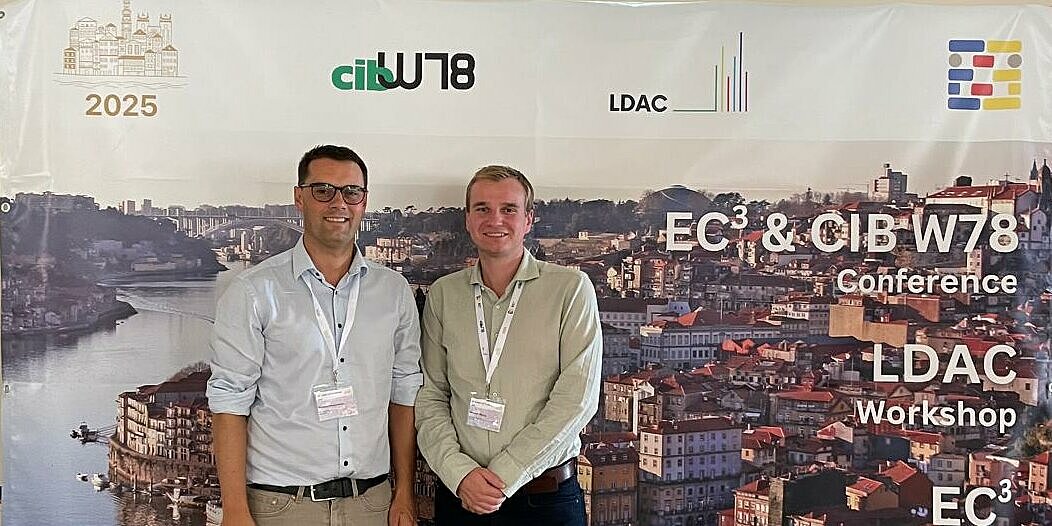 Zwei Personen stehen vor einer Pressewand der European Conference on Computing in Construction (EC³) in Porto. 